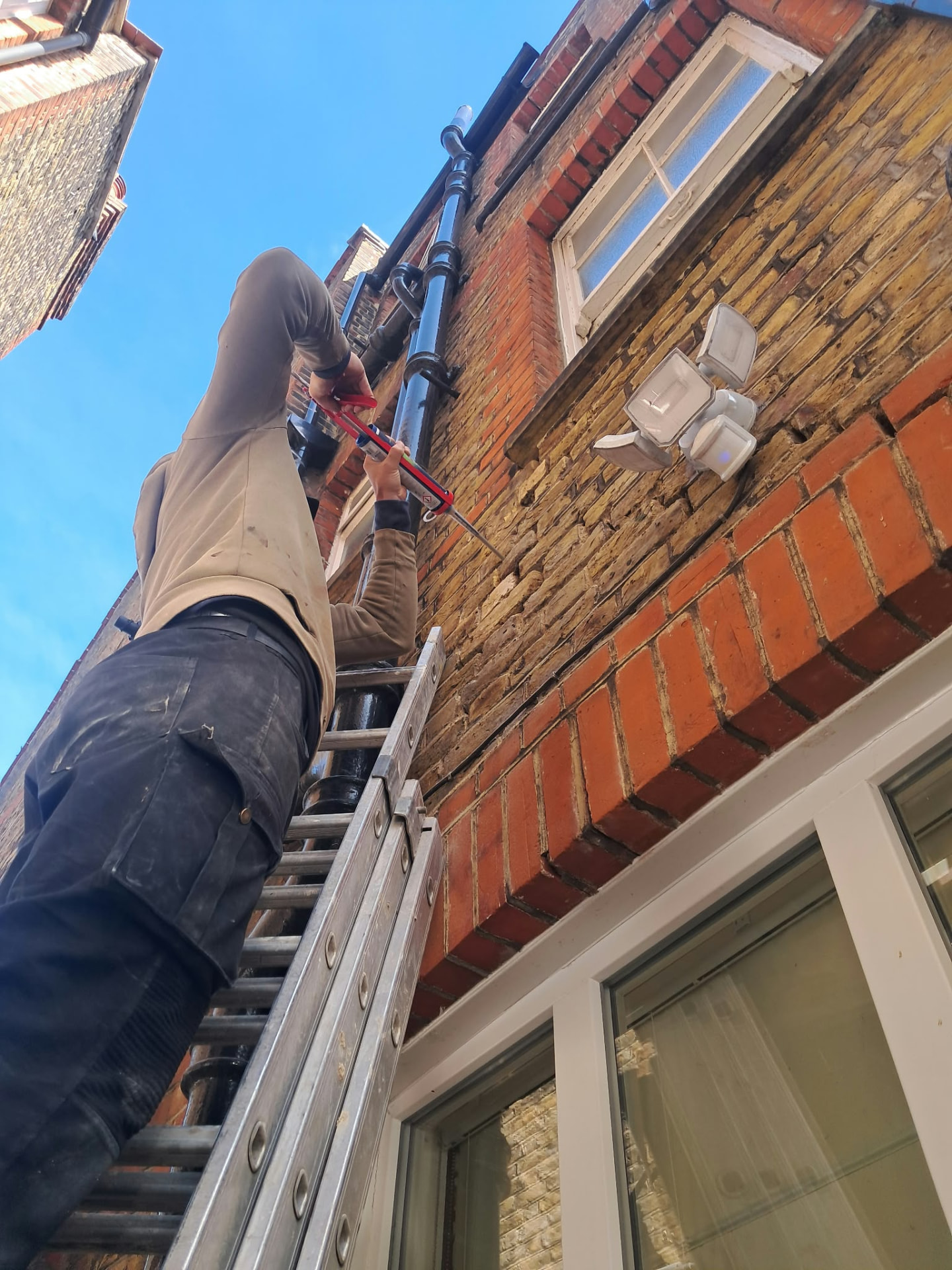 Crack stitching repair being carried out above a window arch in Putney