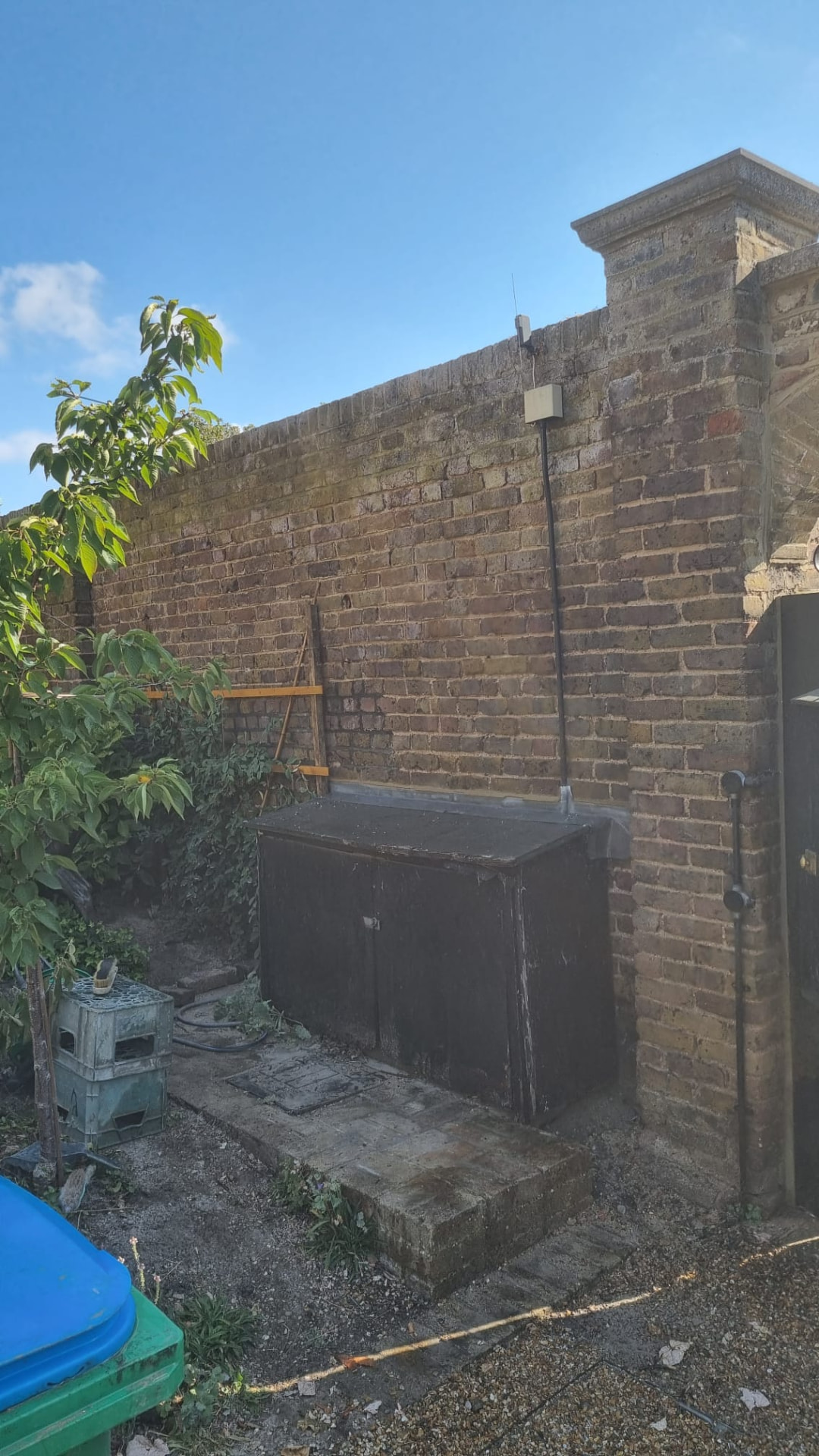 Hampton garden wall with weathered, washed out lime mortar joints before repointing