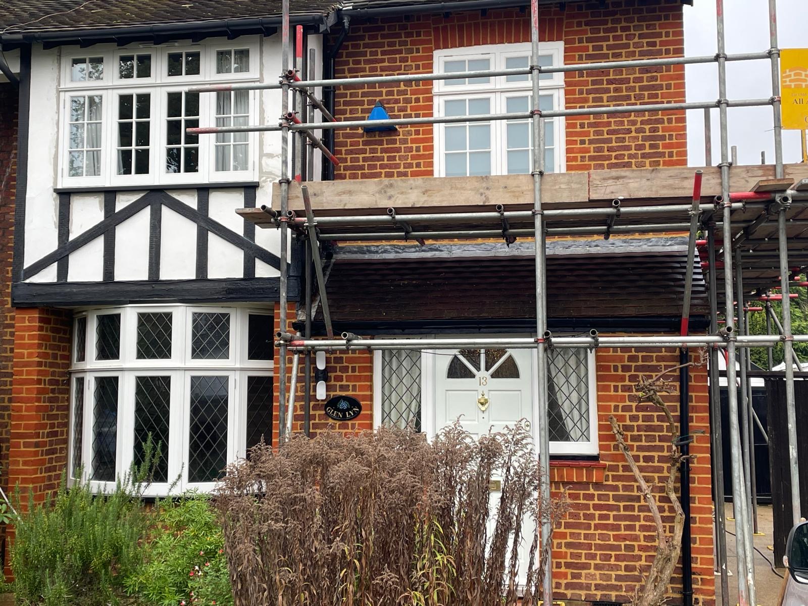 Front elevation of Hampton home with scaffolding across bay window and porch